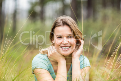 Portrait of a young pretty hiker sitting in the high grass