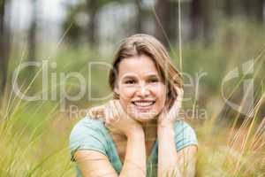 Portrait of a young pretty hiker sitting in the high grass