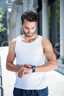 Concentrated handsome athlete setting heart rate watch