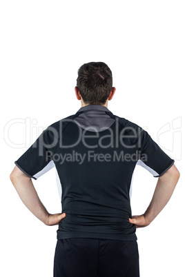 Back turned rugby player with hands on hips