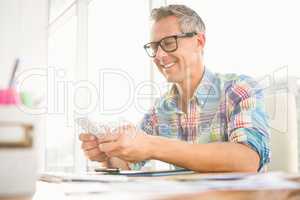 Smiling casual designer using smartphone