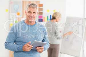 Smiling businessman holding a digital tablet