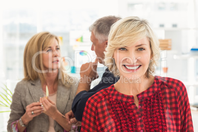 Smiling businesswoman ahead with her team behind