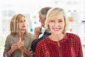 Smiling businesswoman ahead with her team behind