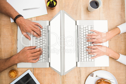 Casual business colleagues working with blank screen laptop