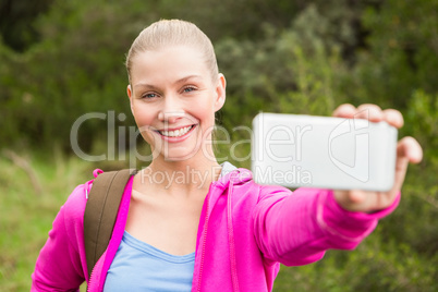 Smiling female hiker taking a selfie