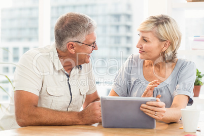 Smiling business team discussing over a tablet