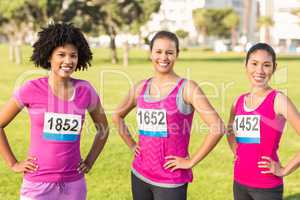 Three smiling runners supporting breast cancer marathon