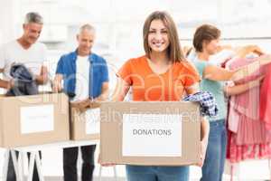 Smiling casual businesswoman holding donation box