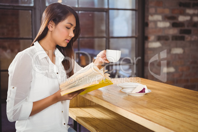 Beautiful businesswoman reading a book