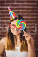 Pretty hipster with party hat and lollipop