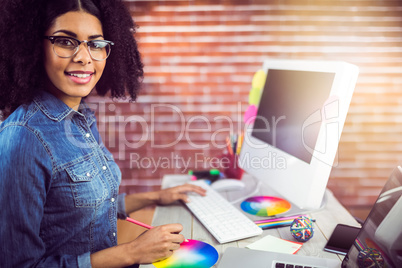 Casual female designer smiling and working