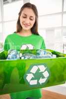 Smiling eco-minded brunette showing recycling box