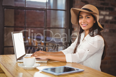 A businesswoman using her laptop while enjoying a coffee