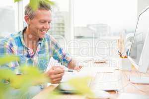 Smiling casual designer working at his desk