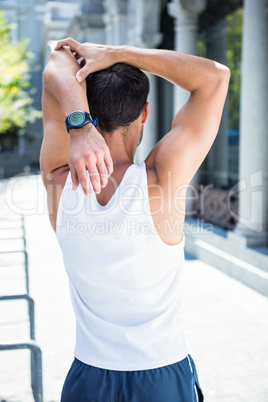 Rear view of athlete stretching his arm