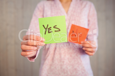 Woman holding yes and no cards