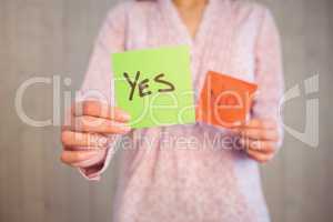 Woman holding yes and no cards