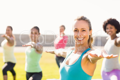 Smiling sporty blonde doing yoga in yoga class