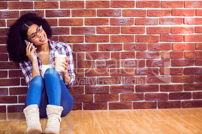 Attractive hipster sitting and phoning with smartphone