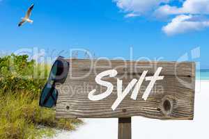 Holzschild mit der Aufschrift "Sylt" am Sandstrand