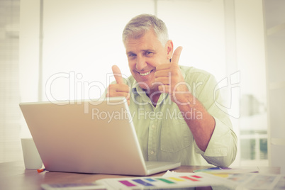 Smiling businessman gesturing thumbs up