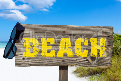 Holzschild mit der Aufschrift "BEACH" am Sandstrand