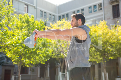 Handsome athlete lifting kettle bell