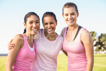 Three smiling women wearing pink for breast cancer