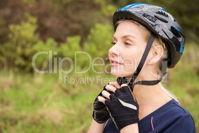 Athletic blonde putting on helmet