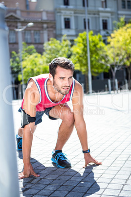 Handsome athlete in running stance