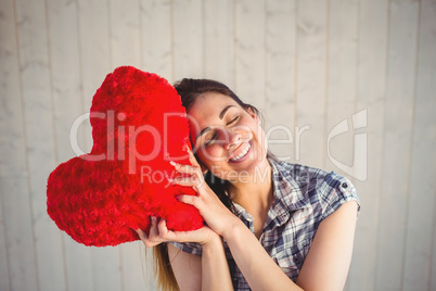 Pretty hipster holding heart pillow
