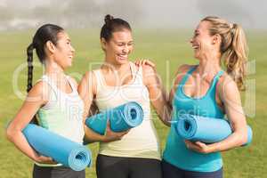 Laughing sporty women with exercise mats