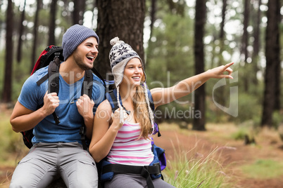 Portrait of a happy hiker couple pointing