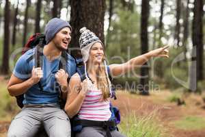 Portrait of a happy hiker couple pointing