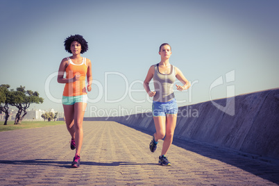 Two young women jogging together