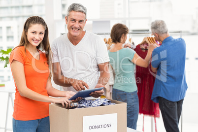 Smiling casual business colleagues with donation box