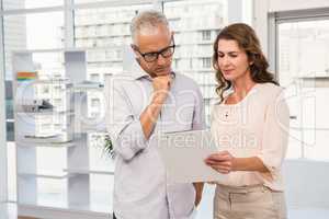 Casual business colleagues looking at clipboard