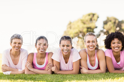 Smiling women lying in a row and wearing pink for breast cancer