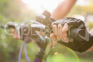Woman mountain biking and holding handlebars