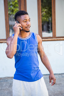 An happy handsome athlete calling