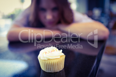 Pretty brunette looking at cupcake