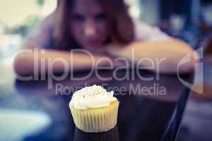 Pretty brunette looking at cupcake