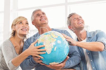 Happy business colleagues holding terrestrial globe