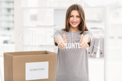 Smiling brunette volunteer doing thumbs up