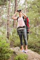 Blonde hiker looking through binoculars