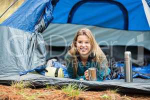 Portrait of a young pretty hiker lying in a tent