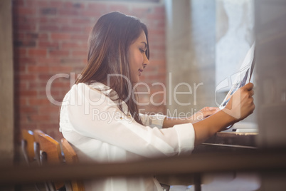 Pretty businesswoman reading newspaper