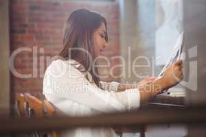 Pretty businesswoman reading newspaper