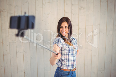 Pretty hipster taking a selfie with stick